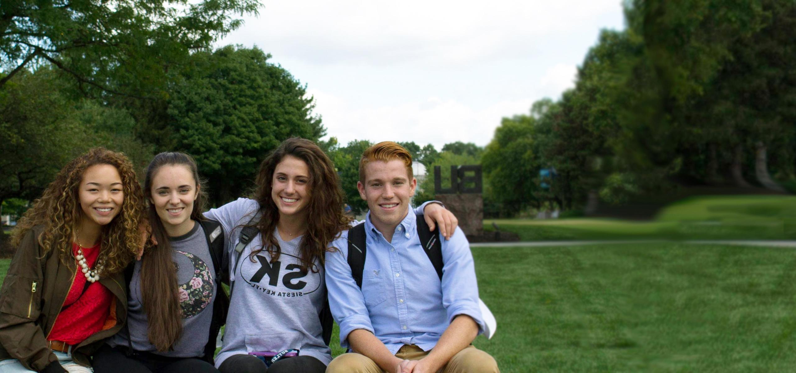 students sitting in front of the BU sign